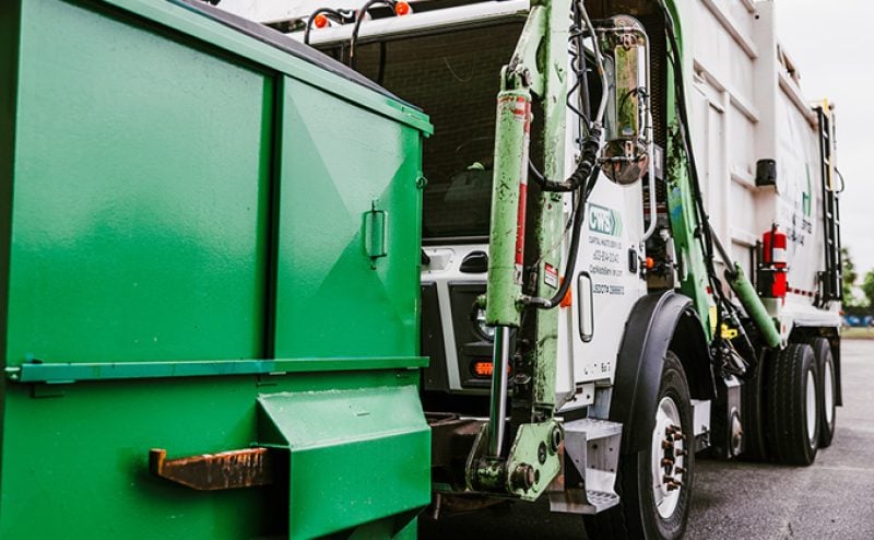 Collection truck grabs dumpster to empty